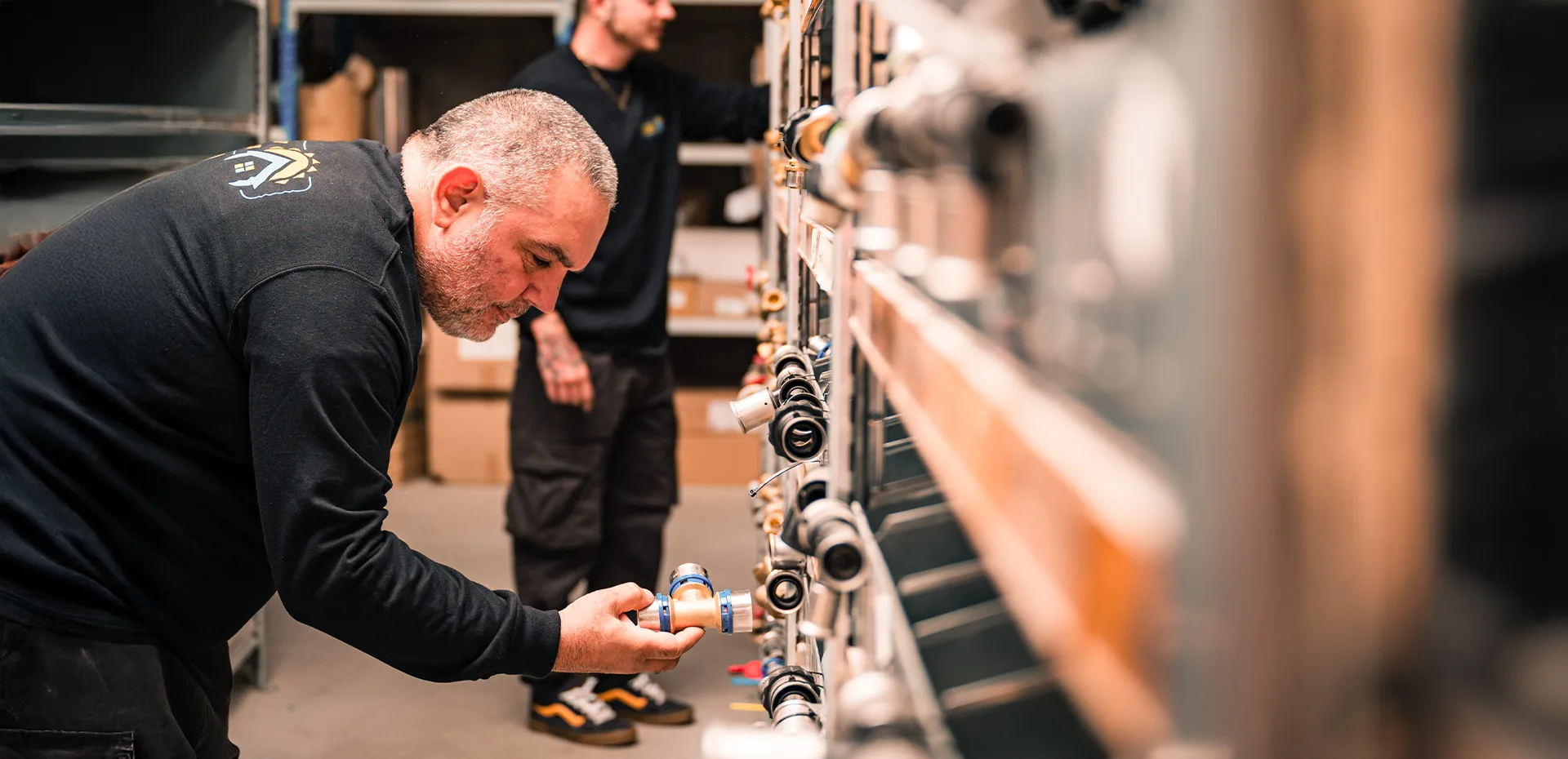 Un ouvrier de l'entreprise Intérieur et chaleur cherche la bonne pièce dans les rangements